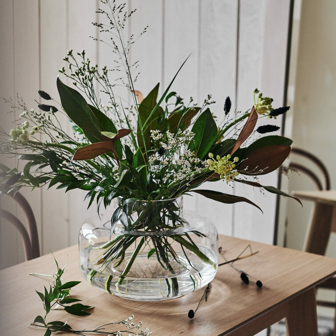 En bukett av hållbara blommor med magnolia, limonium, gräs, ornithogalum och phalaris. Vas Urna från Marimekko.